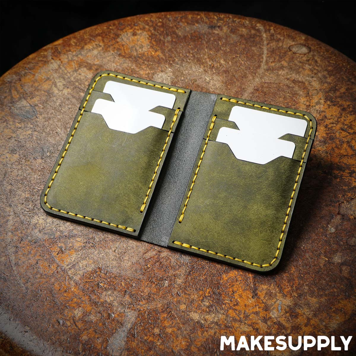 Open vertical leather bifold wallet with card pockets made from olive and black leather