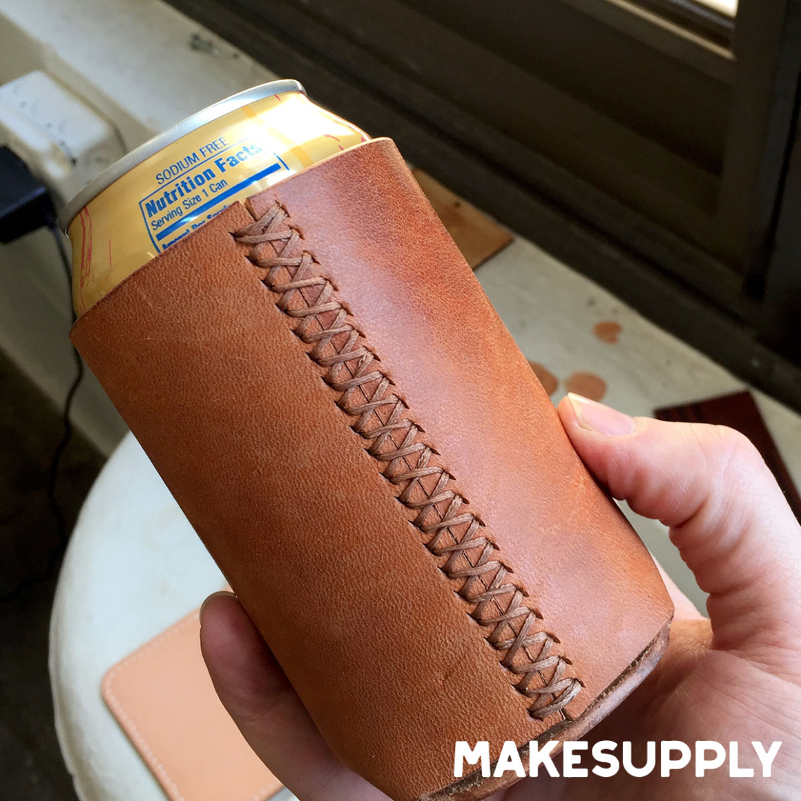 leather koozie holding a beverage can with hand stitched seam
