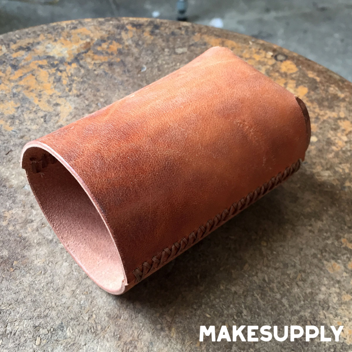 empty leather can koozie showing stitched seam and cylindrical shape