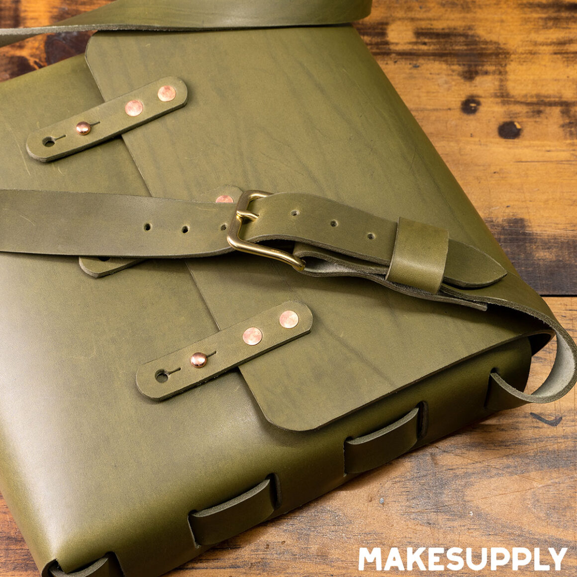 laced leather satchel with buckle closure made from green leather