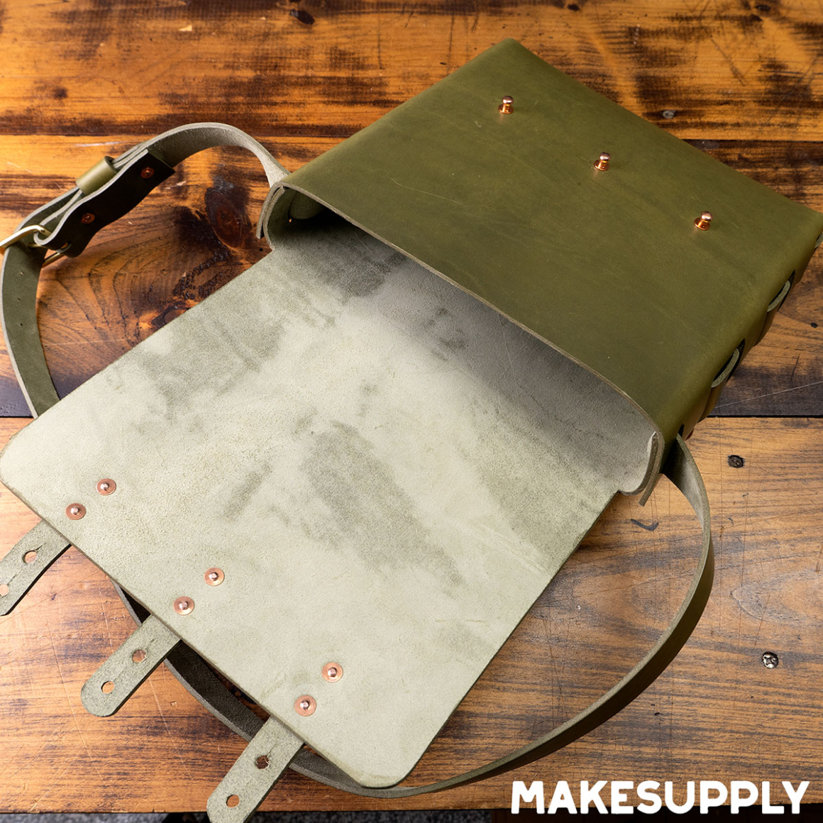 inside view of laced leather satchel showing interior construction and straps