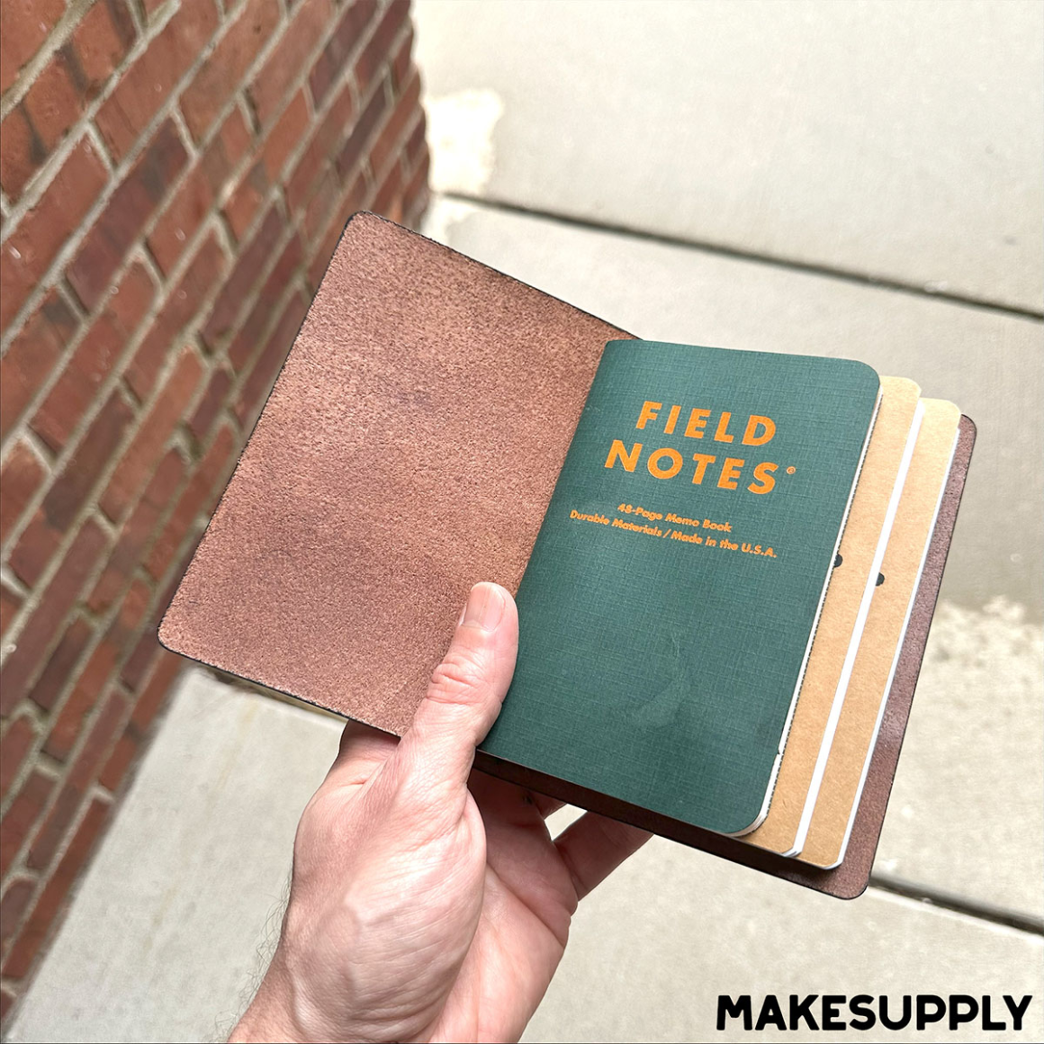 Handheld pocket-size leather journal cover with elastic inserts and Field Notes notebook