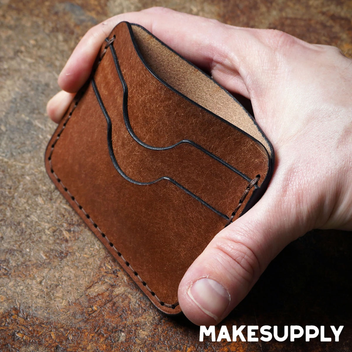 Hand holding a slim leather 5 pocket card holder