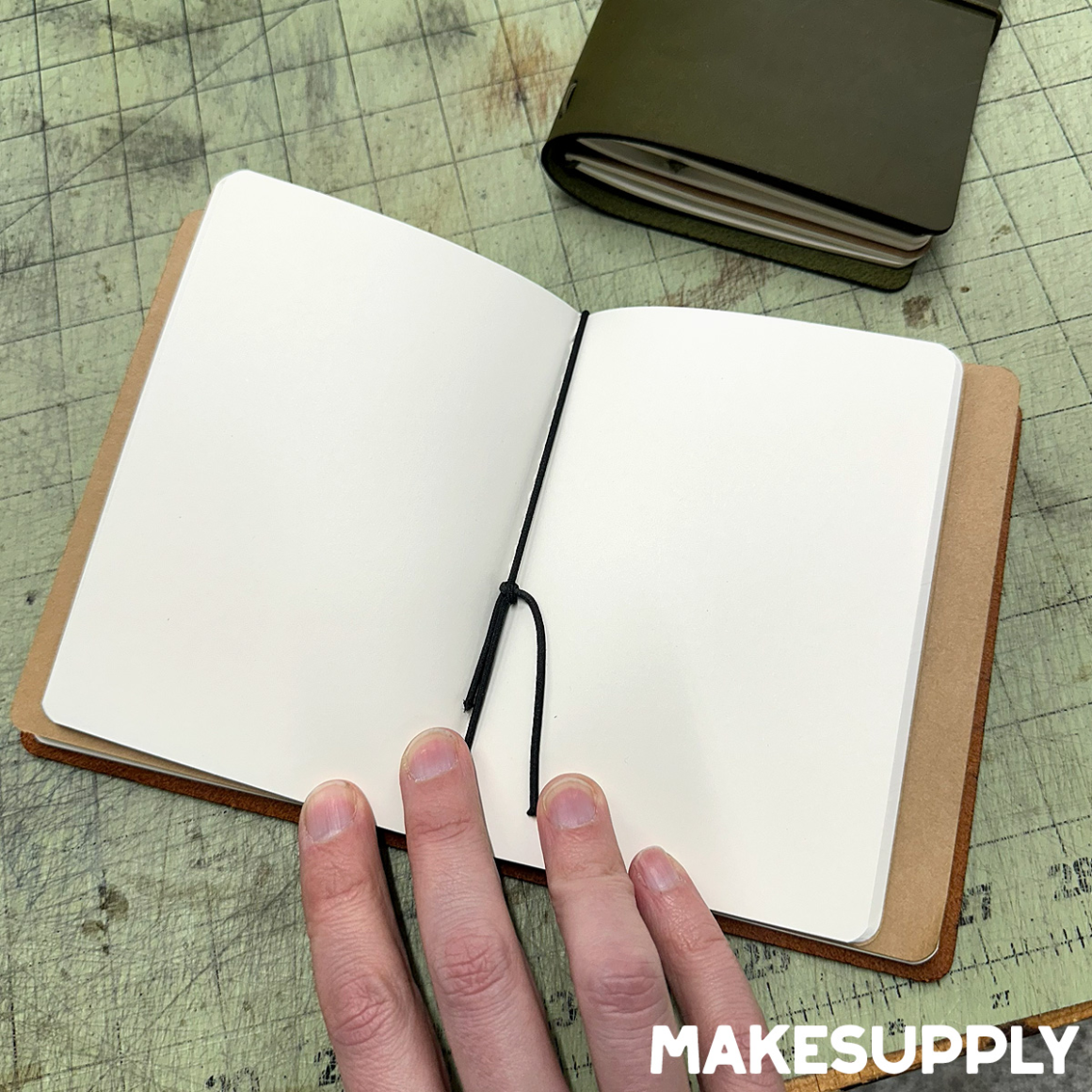 Interior of an A6 traveler style leather notebook cover holding multiple A6 journal inserts