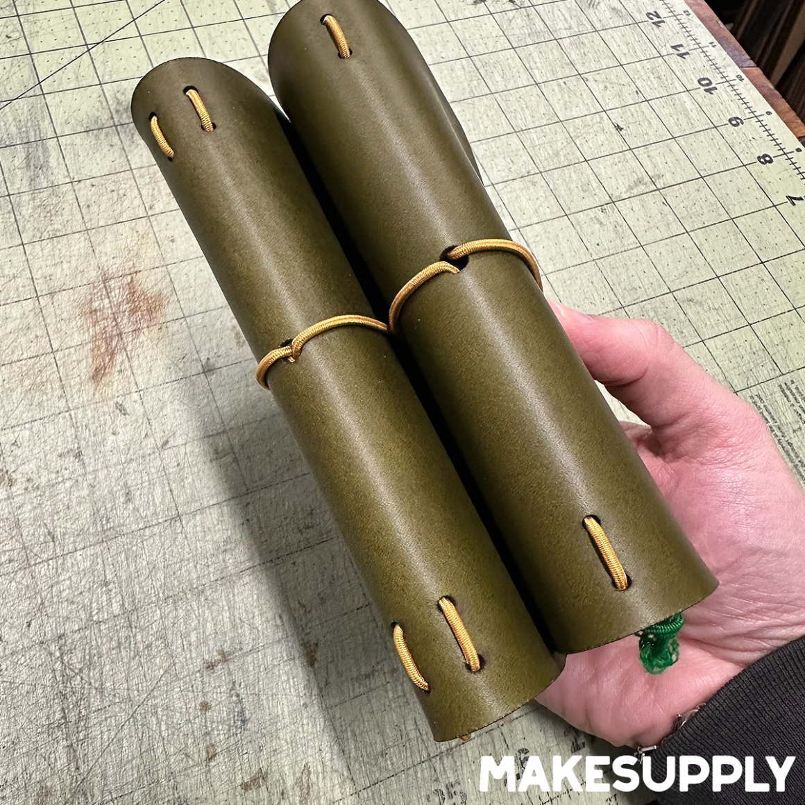 Spine of an A6 trifold leather traveler notebook cover showing elastic cord layout